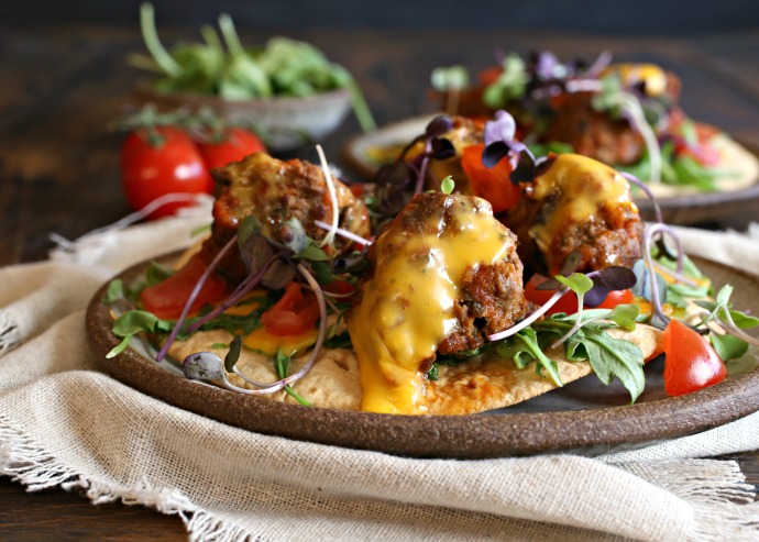 Recipe for meatballs flavored with taco seasonings such as cumin, chili powder and oregano. Served on tortillas.