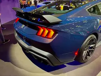 The rear of the Ford Mustang Dark Horse muscle car, featuring a black spoiler attached to the trunk.