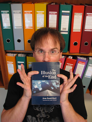 PhD candidate Travis Noakes holds up Jean Bauidrillard's illusion of the end 2010.png