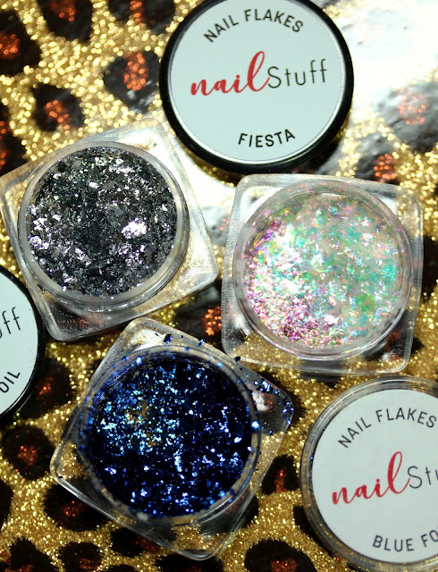 three small jars showing silver, blue and iridescent flakes for nail art