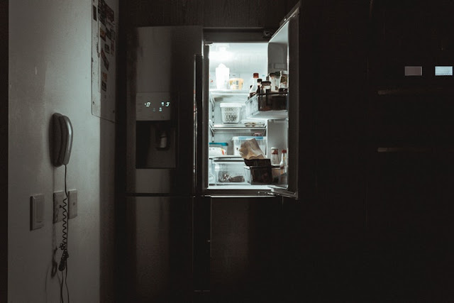 Darkened kitchen with the fridge door open 