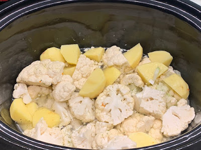 cauliflower soup ingredients in a slow cooker with stock