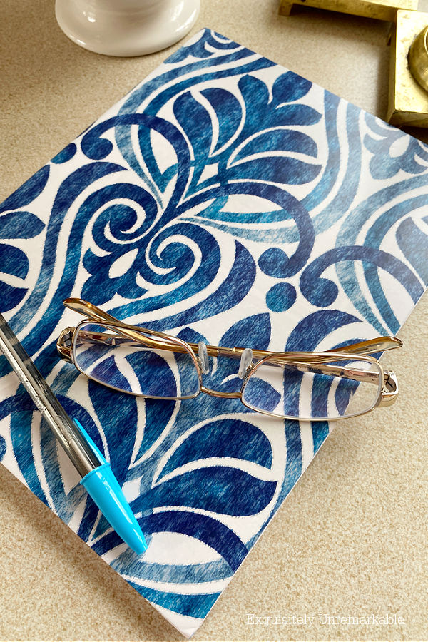 Sticky paper covered notebook on counter with glasses and a pen on top of it