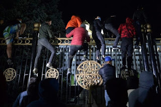 Protesters attempt early on Tuesday to break through the gates of the government headquarters during a rally against the results of a parliamentary vote in Bishkek -AFP