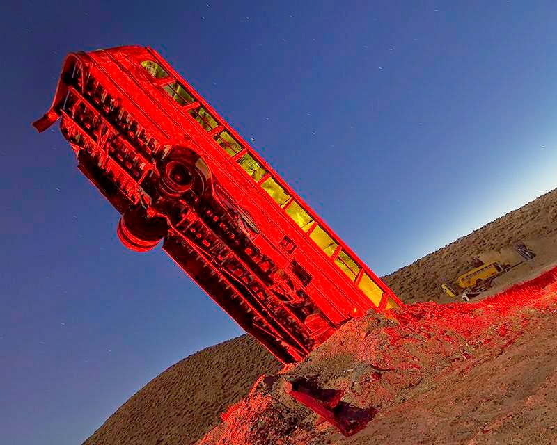 At the edge of Goldfield, a small town in the middle of Nevada, multiple cars, buses, vans, and limos are buried vertically in the desert as if they are growing out of the ground.