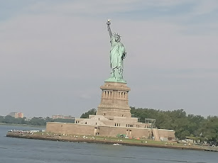 A képen a New York-i szabadságszobor látható, egy női alak egyik kezében magasba emeli a fáklyát a másik kezében az Alkotmánt tartja.