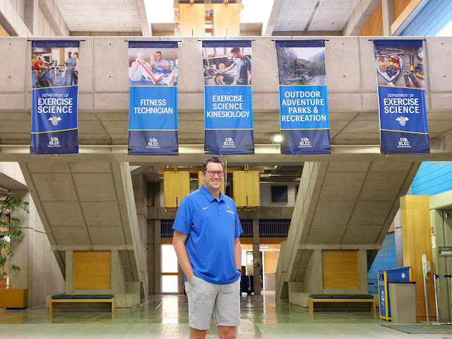 Isaac Wood standing in front of banners in the Lifetime Activities Center.