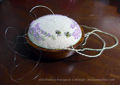 Curved needle and invisible thread used to attach cord to the pincushion