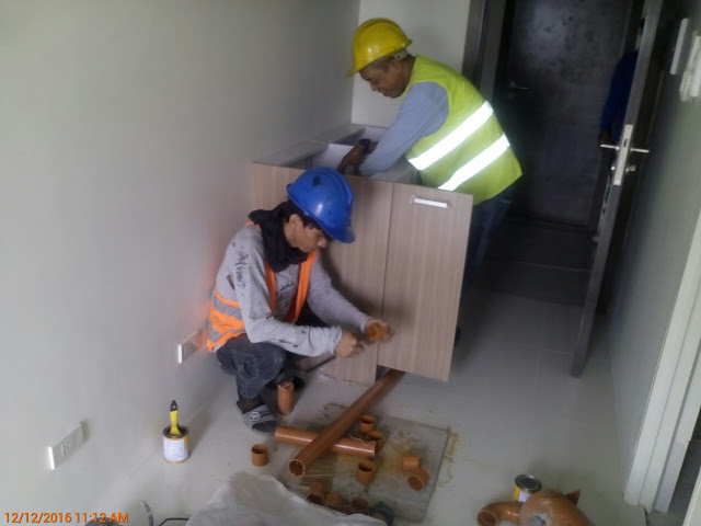 Plumbers installing the grease trap