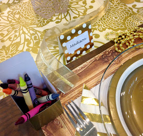 Gold themed party set for a kid.  Crayons and coloring placemat.