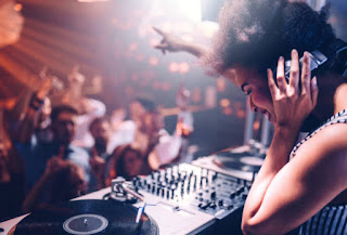 An energetic DJ is playing music at a festival.