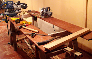 Photo of two saw horses with planks screwed on top to make a large table surface.