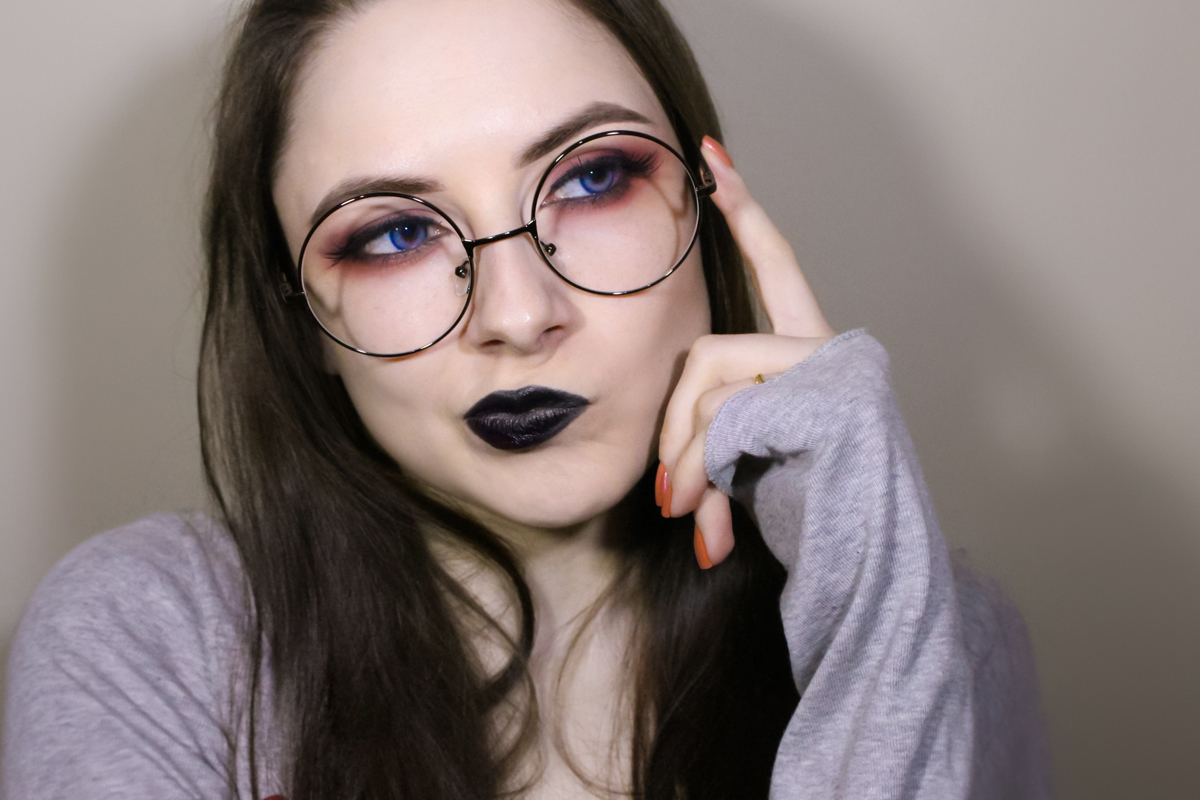 a portrait of a woman wearing round Harry Potter's glasses with bright makeup and black lipstick