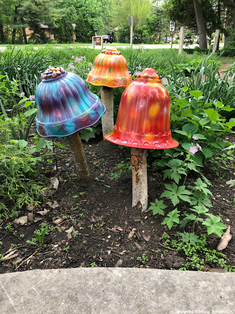 Vibrant multi-colored mushrooms pop from nature's floor as part of a local art pop up at Izaak Walton Park in Prospect Heights, IL.