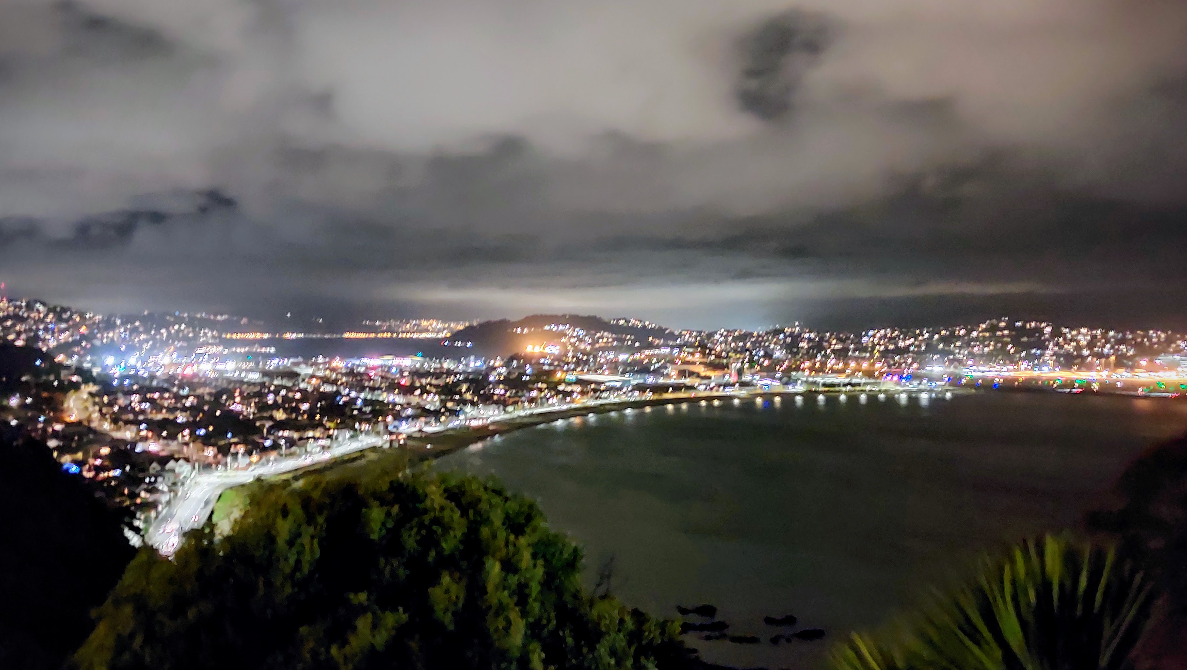 Lights of Kilbirnie and the city bouncing off the low lying clouds and lighting up Lyall Bay as seen from the surrounding hill