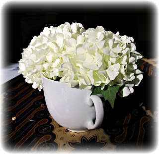 flowers in teacup white pom poms