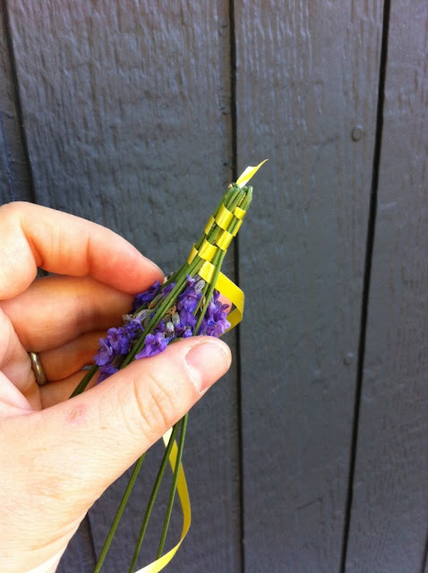 A woman's hand holding a handmade lavender wand.
