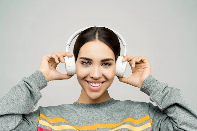 Mujer escuchando música con audífonos. Efectos de la música en el cerebro.