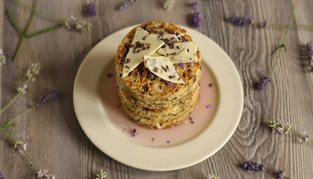 A sweet summery pancake stack with melted white chocolate bits and dried lavender in the batter with some homemade organic lavender syrup and white chocolate bark. Yummy recipe brought to you by the German food blog Pancake Stories. #pancakestories