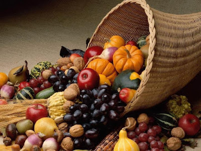 A straw cone-shaped basket with fruits and vegetables spilling from it.