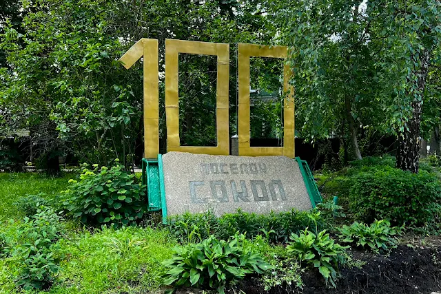 Посёлок Сокол, улица Поленова, улица Сурикова, знак с возрастом поселка «100 Поселок Сокол»