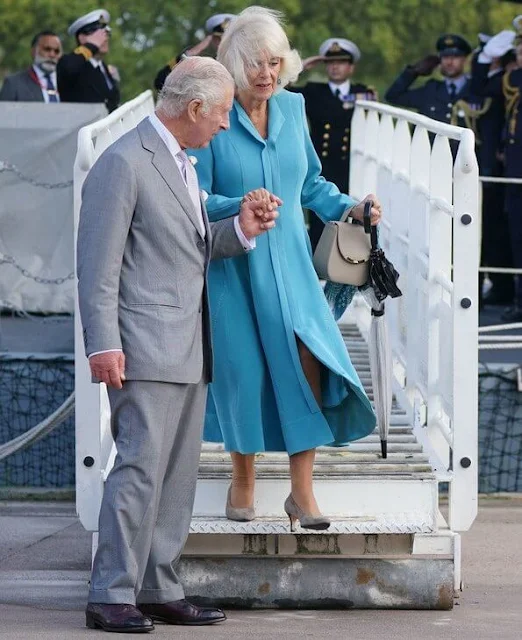 Queen Camilla wore a blue dress coat, and floral print midi dress. Diamond brooch. HMS Iron Duke