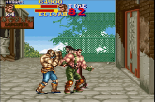 Says HAGGAR with muscle older man looks to him plus 4 lifes and alsi says ELIJAH for the enemy character stats for health with only like 10% left for him and like 70% of character health left. Shows muscle guy with green trousers on and brown boots on showing another blue jeans muscle thug guy in like Hong Kong part of China with wreaked fence at the part of the screen