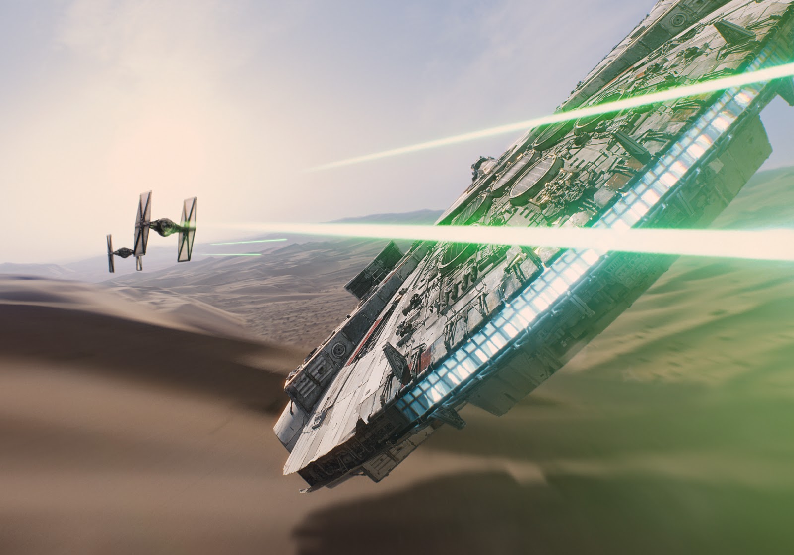 The Millenieum Falcon, flying over a desert, takes on two TIE Fighters.