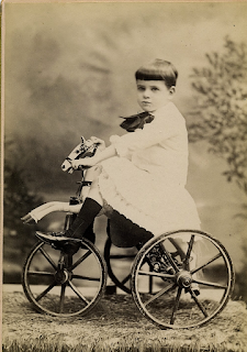 Niño montado en un antiguo triciclo