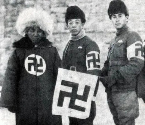 Three Chinese men wearing swastikas and holding a swastika flag.