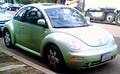 Light green Volkswagen Bug from the side view.