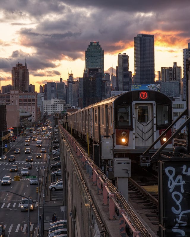 Queensbound 7 train in the sunset with the NYC skyline in the background
