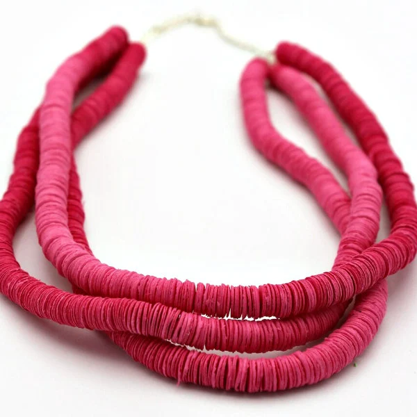 vivid paper necklace of tightly strung discs in shades of pink.