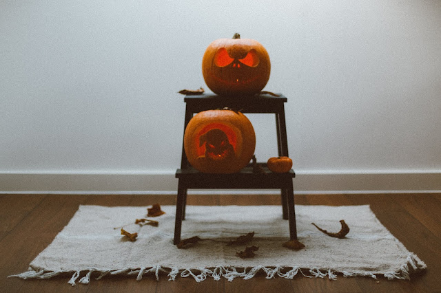 lit carved pumpkins on stand