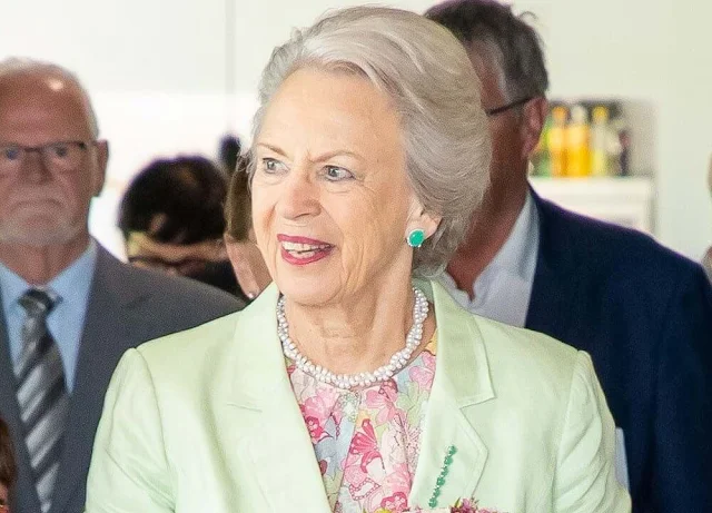 Princess Benedikte wore a floral print midi dress and green blazer. Green earrings and pearl necklace. Chanel two-tone flat shoes