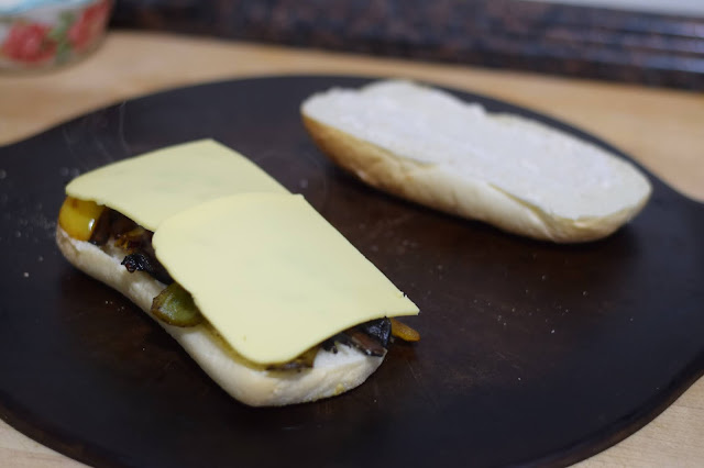 Vegan cheese being added to the mushroom philly.