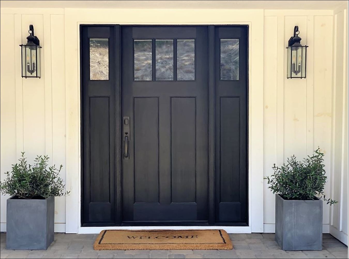 mid-century ranch house exterior home remodel and improvements drought-tolerant plants landscape pavers stone pea gravel black craftsman entry door privacy gate board and batten black and white