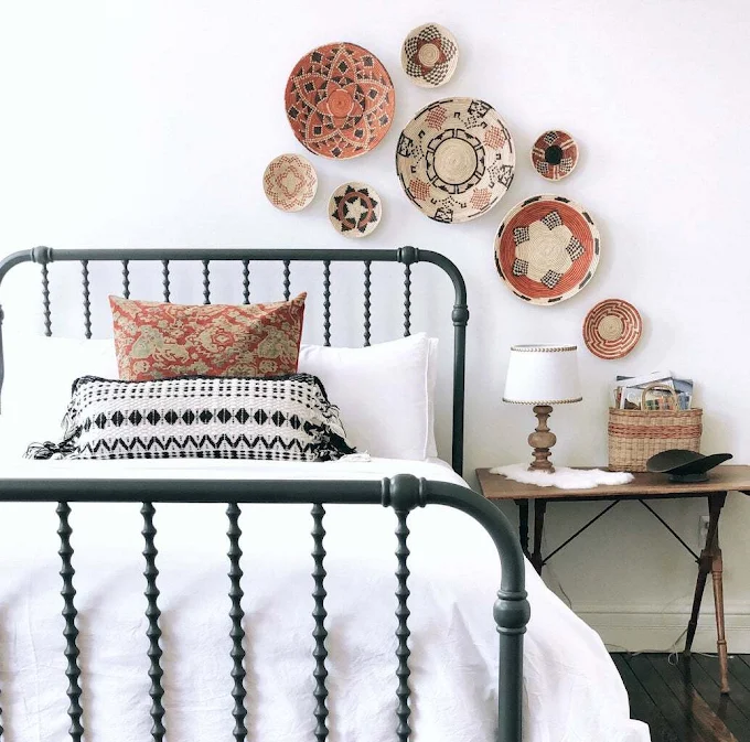 Farmhouse-style basket wall gallery above iron bed