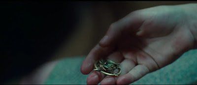 Katniss giving the mockingjay pin to Prim