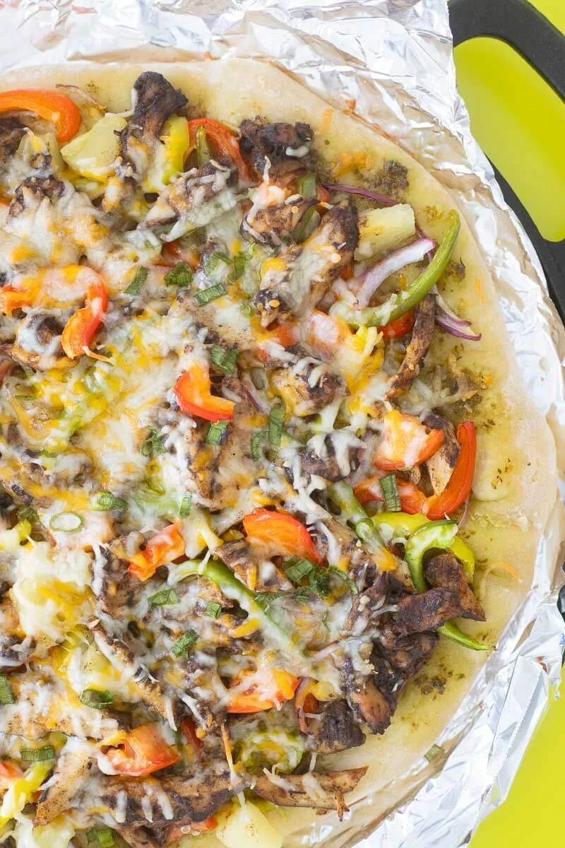 Delicious jerk chicken pizza fresh out the oven with gooey melted cheese.