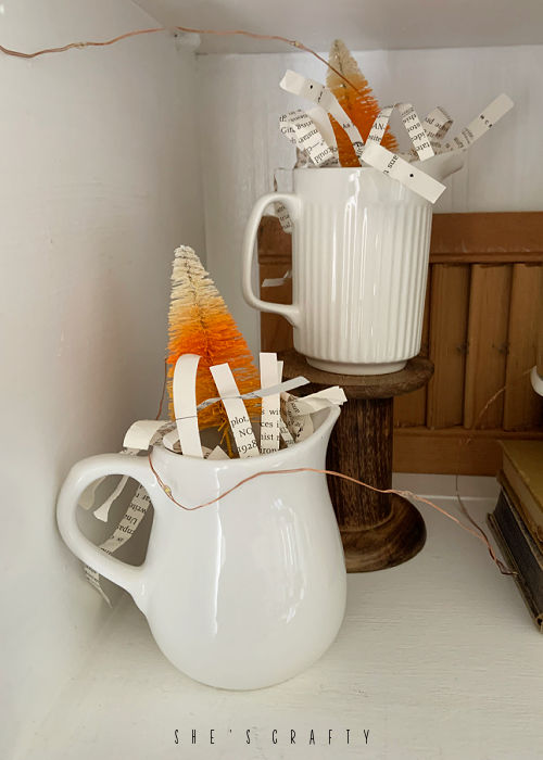 Vintage creamers with candy corn bottle brush trees.