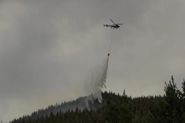 Một số máy bay trực thăng mang theo thùng chứa bọt chữa cháy tiếp tục làm việc để ngăn chặn đám cháy ở Thung lũng Lee gần Nelson vào sáng thứ Năm.  NGUỒN: BRADEN FASTIER/STUFF