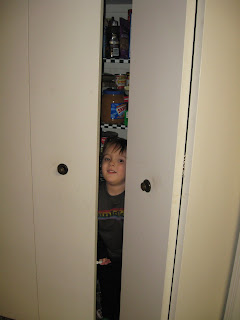 Brian peaking out from inside the folding doors to the pantry