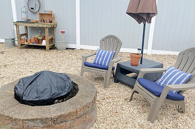 fire pit area with chairs, umbrella and potting table