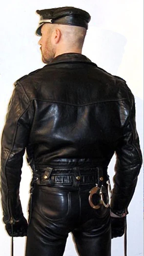 Rear view of a Leatherman wearing full gear and a Muir cap from the buttocks up