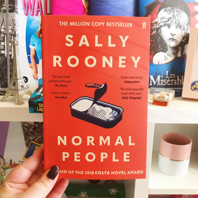 Normal People by Sally Rooney book held up in front of desk