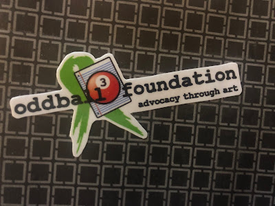 Sticker: 3-Ball with green ribbon: "Oddball Foundation - Advocacy Through Art"ll with green ribbon: