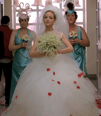 Emma in a wedding dress with Sue and Shannon behind her in crazy bridesmaid dresses