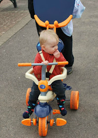 Baby on blue and orange trike