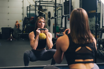 cute girl squatting kettle bell 